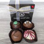Box of four decorated chocolate truffles with a ribbon bow
