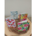 Four floral greeting cards on a wooden slice