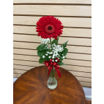 Red gerbera daisy arrangement in a glass vase with baby's breath and a red ribbon