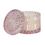Pink faceted glass candle holder with a white candle inside