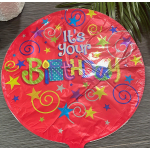 Round red birthday balloon with colorful stars and swirls