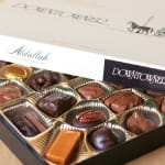 Open box of assorted chocolates in gold paper cups