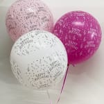 Three birthday balloons in pink and white with printed confetti patterns