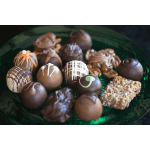 Assorted chocolate truffles and candies on a green tray