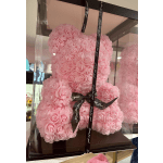 Pink teddy bear made of small rose-shaped flowers in a clear box
