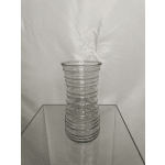 Clear ribbed glass vase on a reflective surface