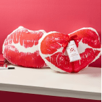 Red and white heart-shaped pillow with a ribbon tag