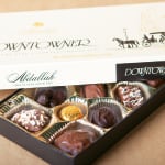Open box of assorted chocolates in gold cups