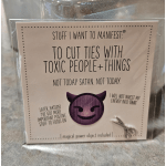 A packaged novelty card with a small pair of scissors attached