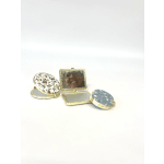 Three small floral compact mirrors with gold trim on a white background
