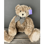 Large tan plush teddy bear with a checkered bow sitting on a wooden surface