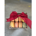 Box of colorful macarons tied with a red ribbon