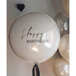 White birthday balloon with black text and a ribbon tail