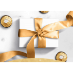 White gift box tied with a gold satin ribbon, surrounded by gold-wrapped chocolates