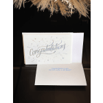 White congratulations card with holographic lettering and starburst accents
