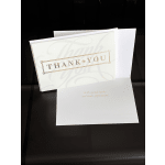 White thank-you greeting card with gold lettering on a dark background.