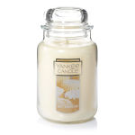 Cream-colored candle in a glass jar with a lid