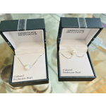 Two pearl necklaces in open jewelry boxes
