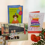 Birthday cards displayed with a few orange and white flowers