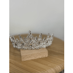 Silver jeweled tiara resting on a small wooden block