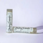 Two strawberry cheesecake beeswax lip balm tubes on a light background