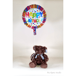 Birthday balloon tied to a brown teddy bear