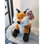 Plush fox toy sitting on a lace doily