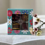 Box of chocolate truffles beside a small sprig of pink and white flowers