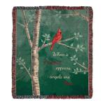 Woven throw blanket with red cardinal on tree branches and the phrase 'When a cardinal appears, angels are near'.
