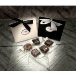 Two ribbon-tied gift boxes with wrapped chocolates on the floor