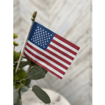 Small American flag on a floral stem among greenery