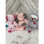 Three plush stuffed animals sit side by side on a marble surface.