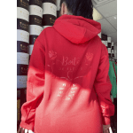 Person wearing a red hoodie in front of stacked flower boxes
