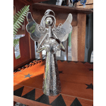 Silver angel figurine with patterned wings standing on a wooden surface