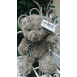 Plush teddy bear with a plaid bow and decorative metal scrollwork