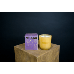 Purple candle box beside a yellow glass candle jar on a wooden block