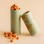 Two floral-patterned tins filled with orange sugar cubes