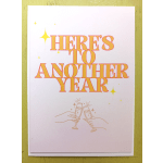 Greeting card with “Here’s to Another Year” text and hands clinking champagne glasses.