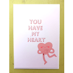 White greeting card with pink text 'You Have My Heart' and a smiling pink heart character hugging itself.
