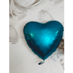 Teal heart-shaped foil balloon on a white fabric background