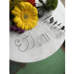 Yellow gerbera daisy with red roses and purple flowers on a round sign