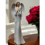 Angel figurine beside a vase of bright pink flowers