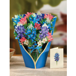 Bouquet of blue, purple, and pink flowers in a blue wrap with a ribbon