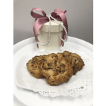 Gift box with pink ribbon behind three large cookies on a white plate with a lace doily