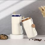 Two insulated coffee tumblers with hanging straps and lids