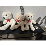 Three teddy bears with red bows sit on a black table.