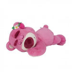 Pink plush bear toy lying on its side with a small flower on its head