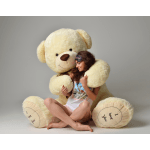 Woman sitting with a giant cream teddy bear