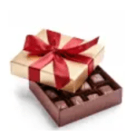 Gift box with a red ribbon on top of an open box of chocolates