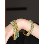 Pair of gold bangles with turquoise stones on a wrist